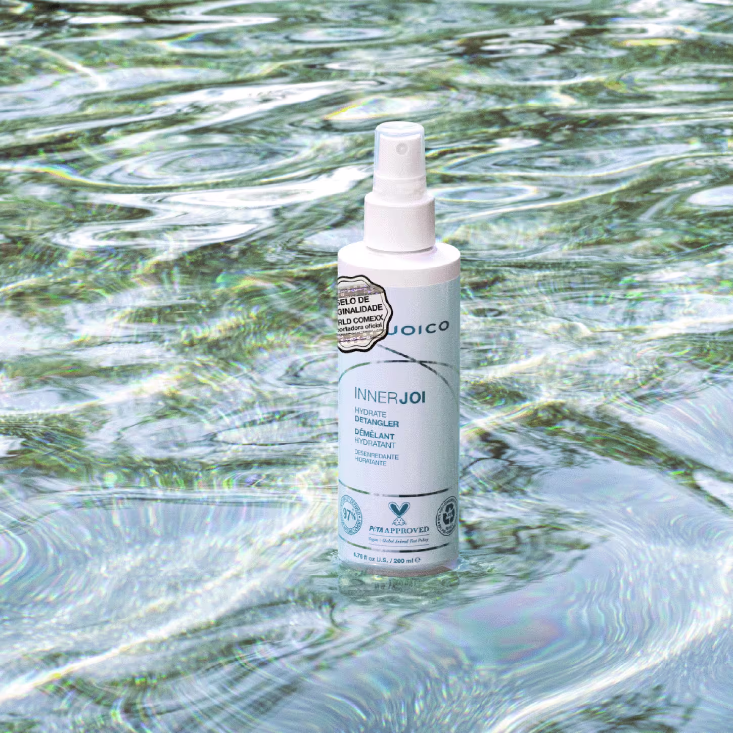O Leave-in Joico InnerJoi Hydrate Detangler (200ml), em sua embalagem verde com detalhes em branco, se destaca em um fundo que lembra água cristalina, transmitindo uma sensação de leveza e frescor