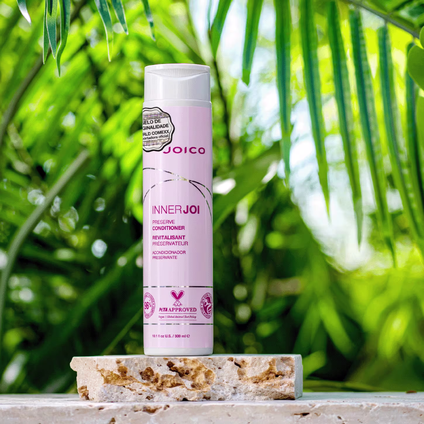 O Condicionador Joico InnerJoi Preserve (300ml) destaca-se sobre um fundo que evoca a natureza, com folhas verdes e pedras.