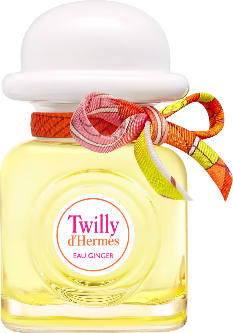 Frasco transparente onde é possível ver o líquido amarelo por dentro. Formato quadrado, com tampa arredondada branca e um laço laranja amarrado.