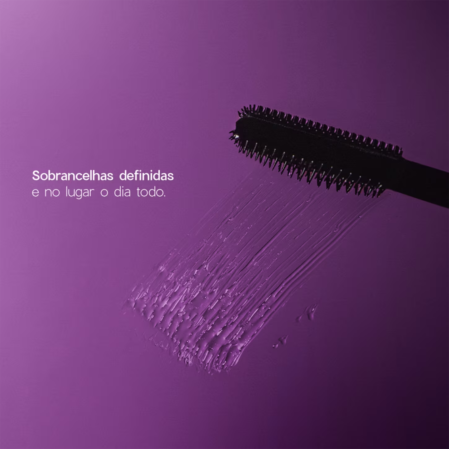 A imagem mostra escova aplicadora do gel para sobrancelhas em um fundo roxo, com amostra do produto em gel incolor riscado. Traz ainda o texto: "Sobrancelhas definidas e no lugar o dia todo"