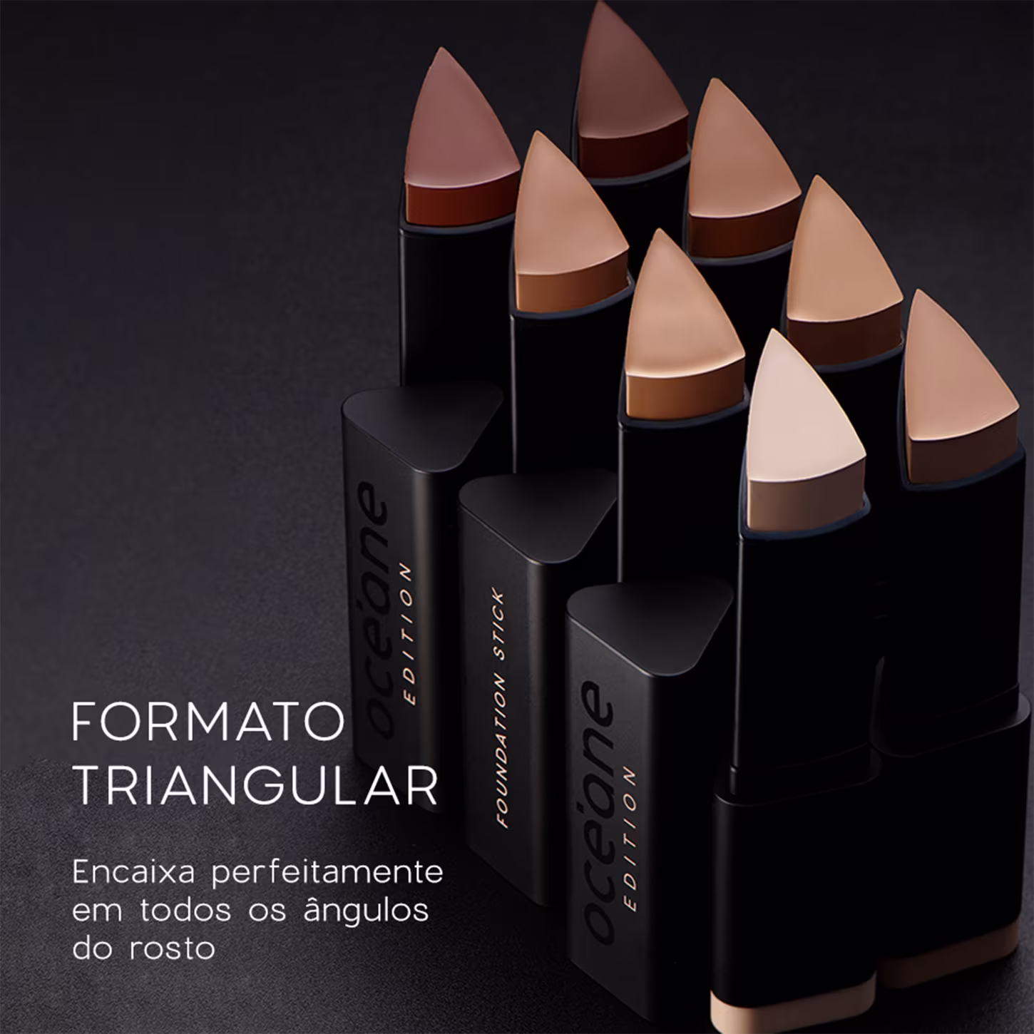 A imagem traz um fundo preto e as 8 cores da Base Océane Edition Foundation Stick enfileiradas, em embalagens pretas e mostrando os diferentes tons. Ao lado, aparece o texto "Formato Triangular" para encaixar perfeitamente nos ângulos do rosto.