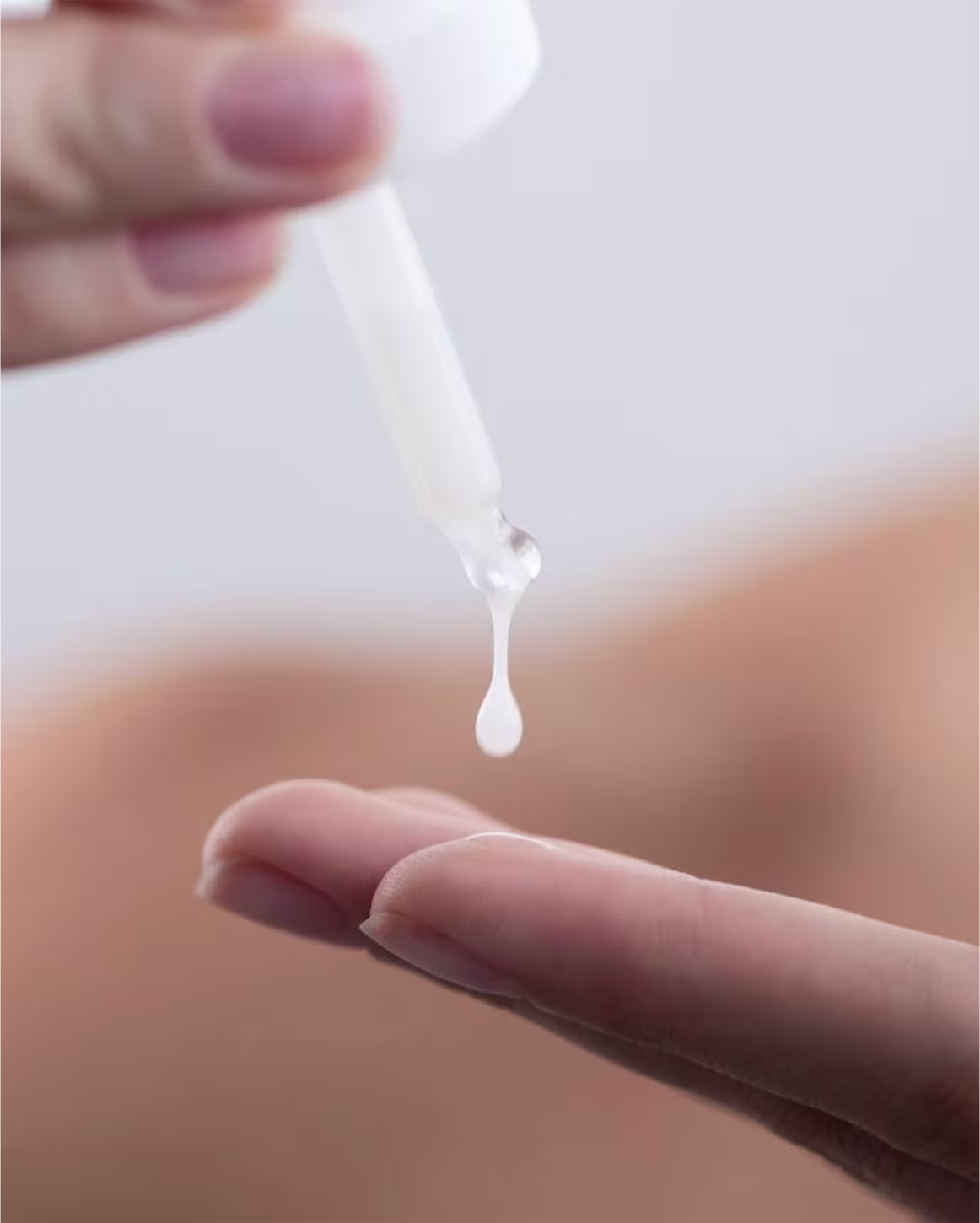 A imagem mostra uma gota do sérum pingando nas mãos.