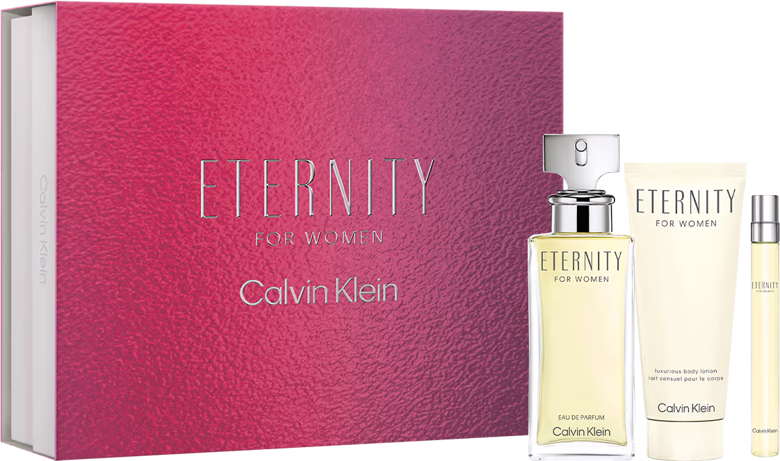 Frasco de perfume de vidro transparente com líquido dourado e tampa prateada, um frasco menor de loção corporal e uma amostra tamanho viagem. A embalagem é uma caixa retangular rosa com o nome "Eternity" e o logotipo Calvin Klein em letras prateadas.
