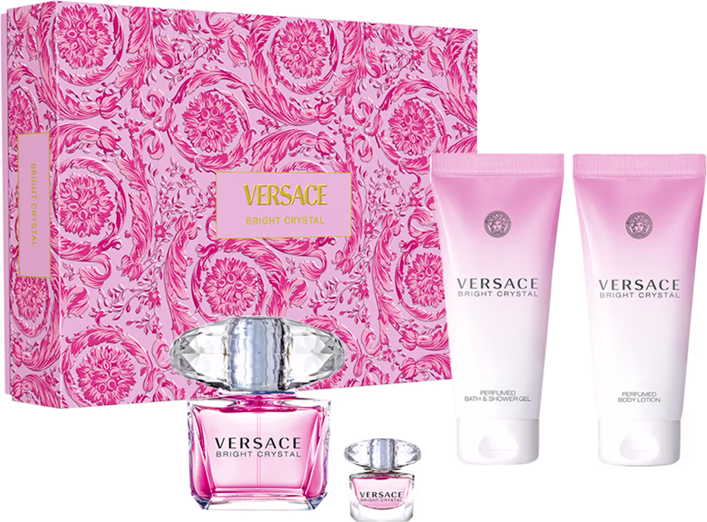 A imagem mostra um frasco de perfume de cristal transparente com líquido rosa e outro frasco igual menor acompanhado de dois tubos com tom degradê rosa e branco. Os itens vem em uma caixa retangular com estampa floral rosa e branca em padrão barroco.