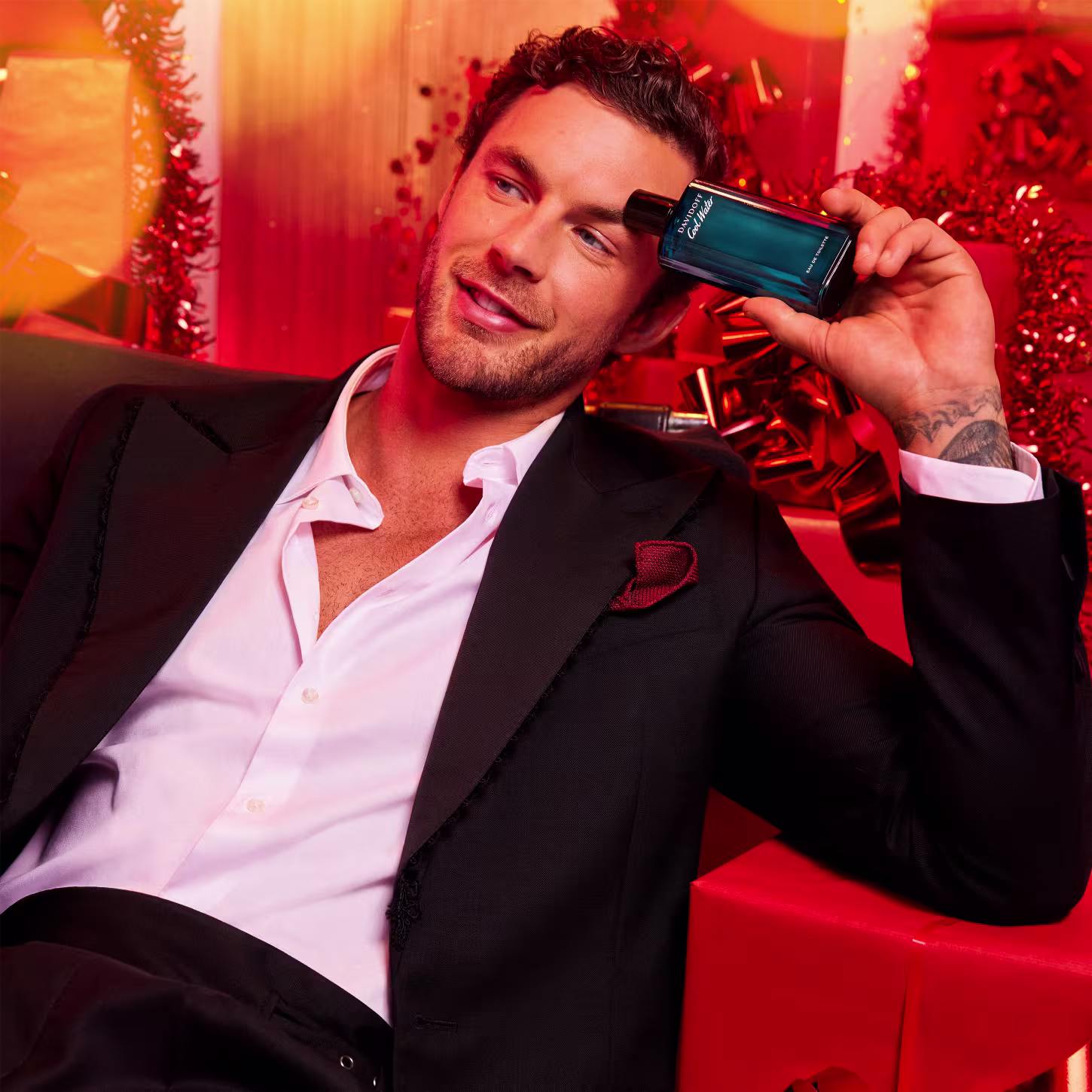 A imagem mostra um homem segurando um frasco de perfume.