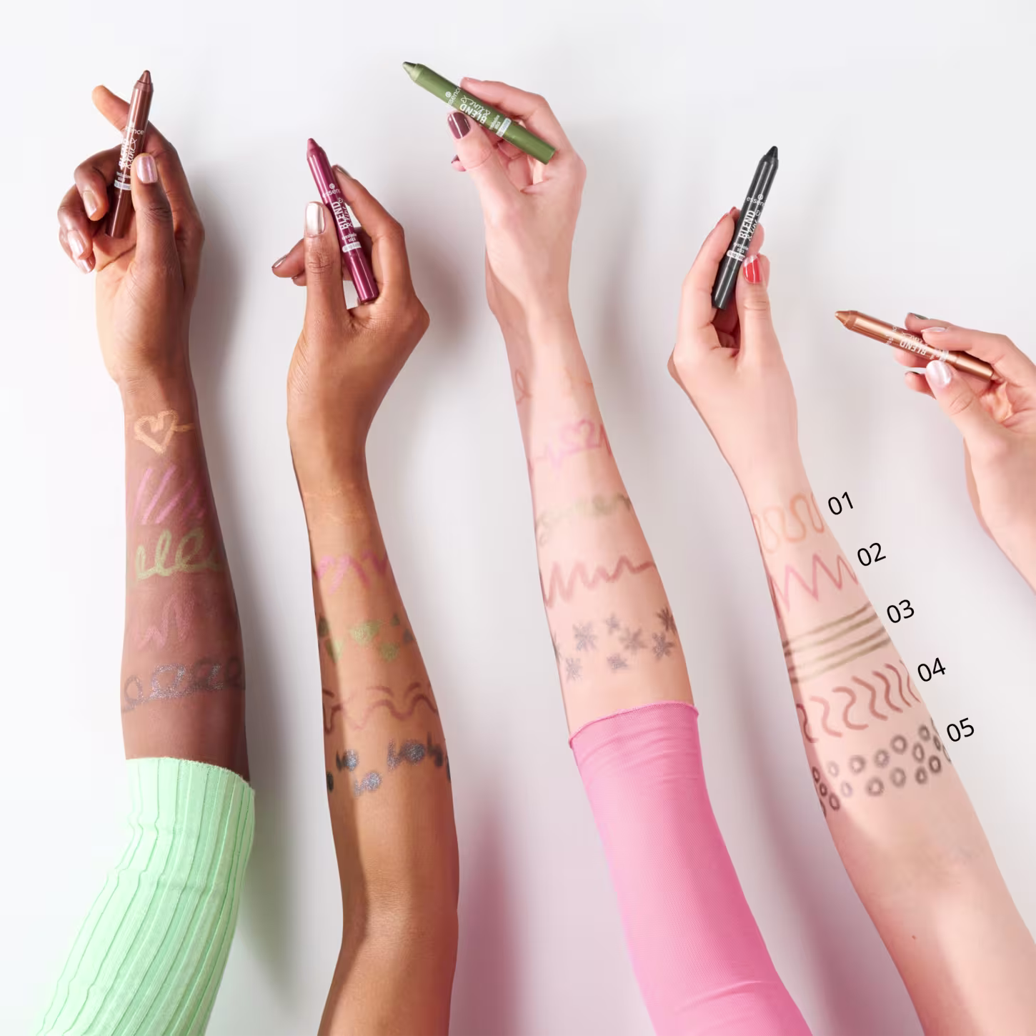 Quatro braços de pessoas com cor de pele distintas. Eles estão pintadas com as cores disponíveis na paleta para demonstrar como cada tom fica em diferentes peles.