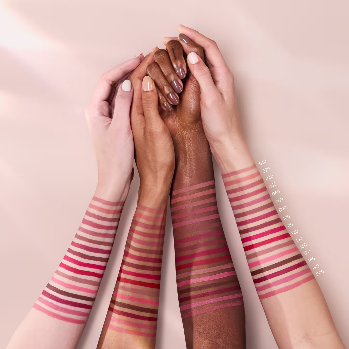 4 braços de cores de pele diferentes com listras coloridas, simulando as amostras de cores em diferentes pessoas.
