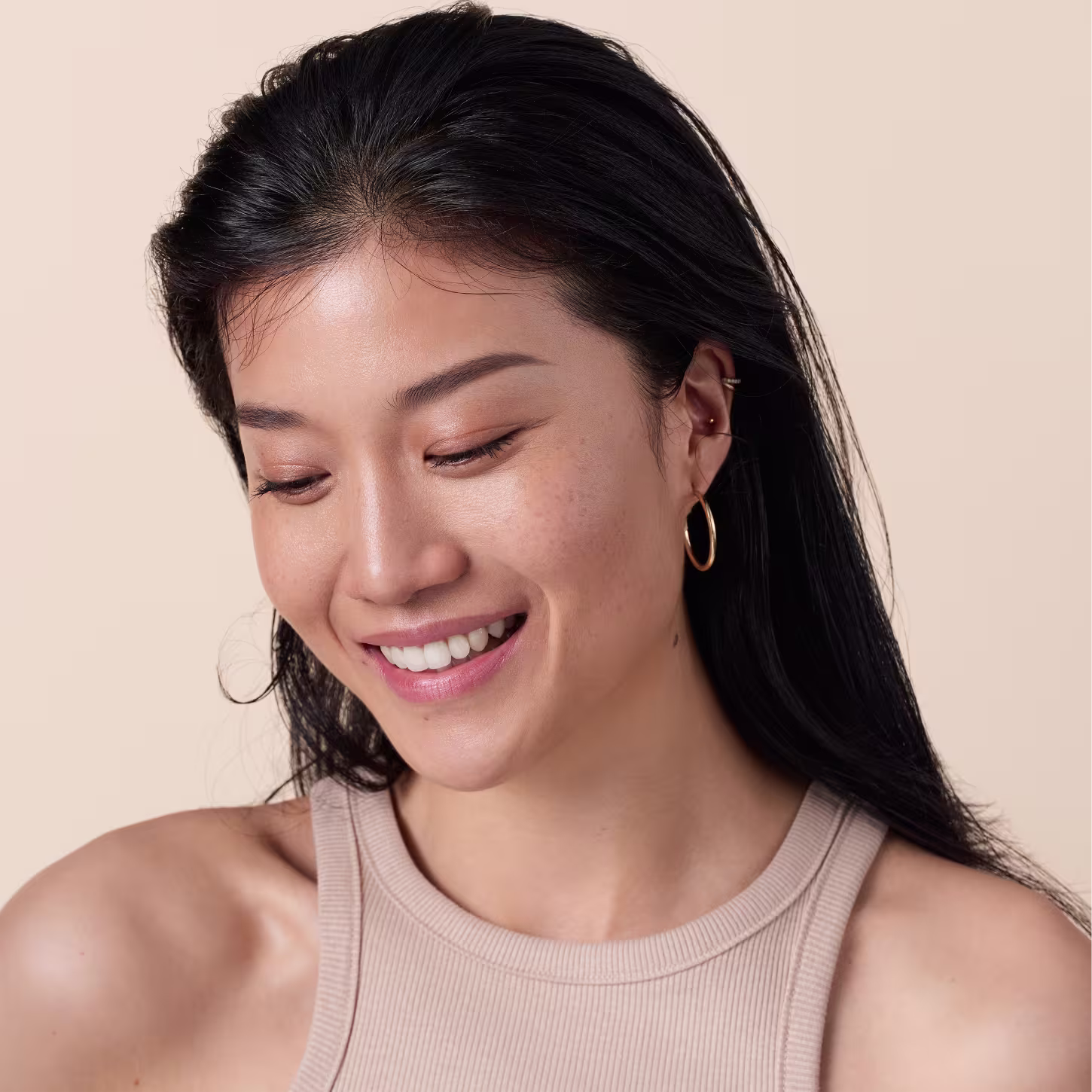 Modelo asiática com cabelos longos e pretos sorrindo.