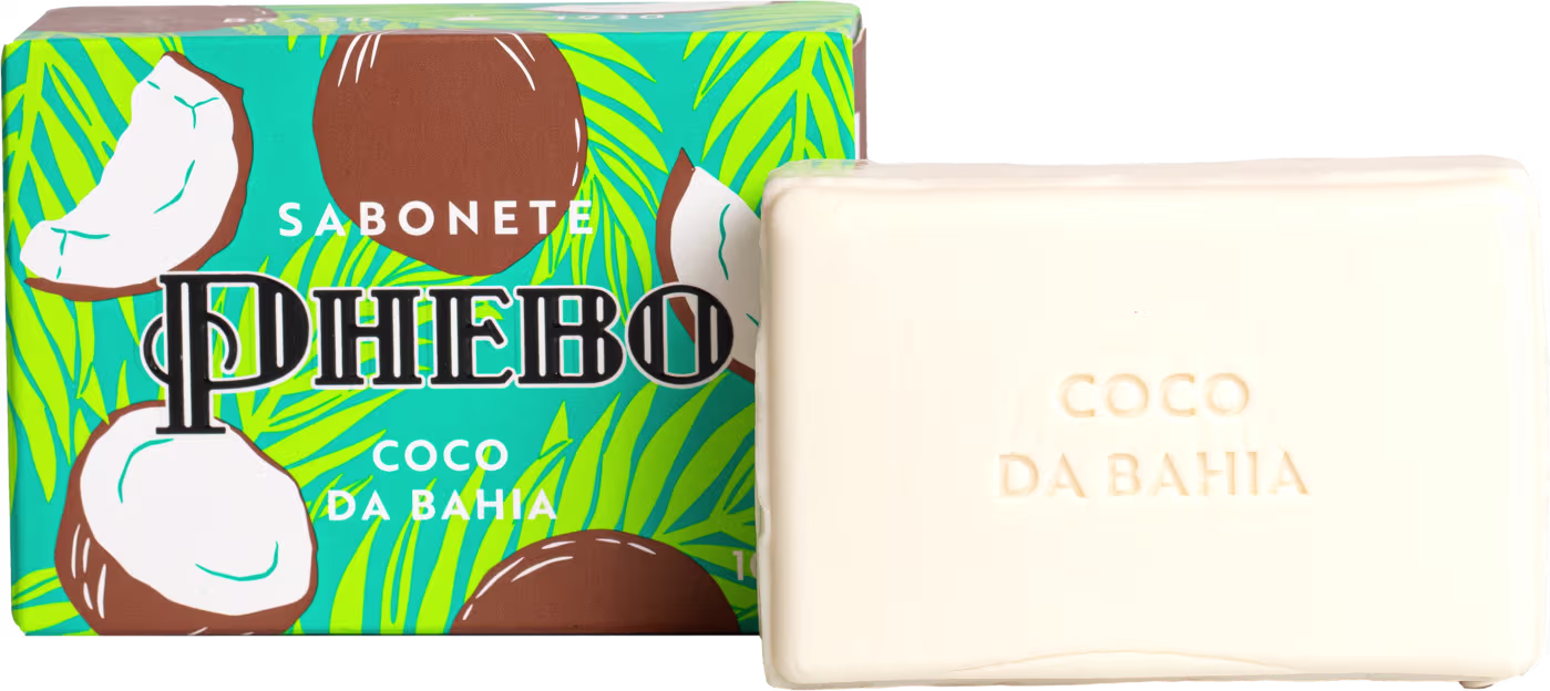 Sabonete em barra. A embalagem é uma caixa retangular com fundo turquesa e detalhes em verde limão e marrom, apresentando ilustrações de coco e um pássaro branco. O sabonete é uma barra retangular branca com o texto "Coco da Bahia" gravado na superfície.