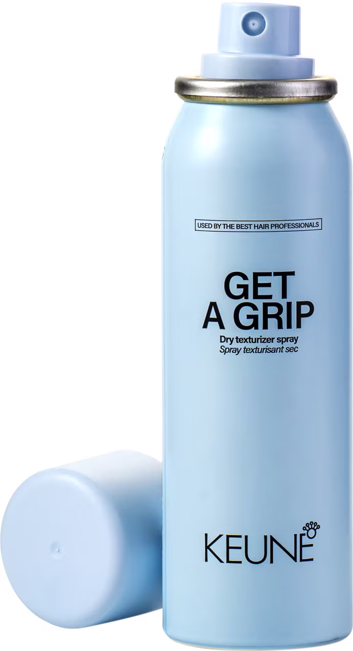 A imagem apresenta o produto Keune Get a Grip aberto, com a tampa ao lado, mostrando o aplicador em spray.