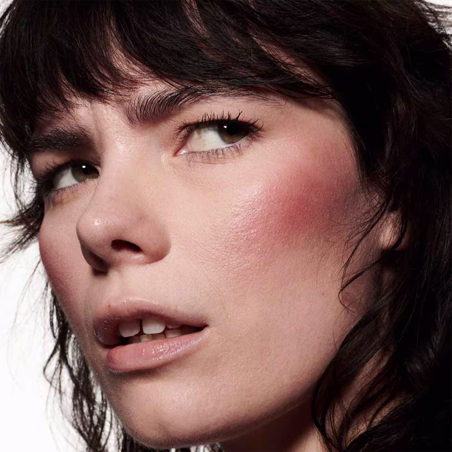 A imagem mostra uma modelo com a pele branca e o efeito de cor do Blush Líquido M·A·C Strobe Unsweetened