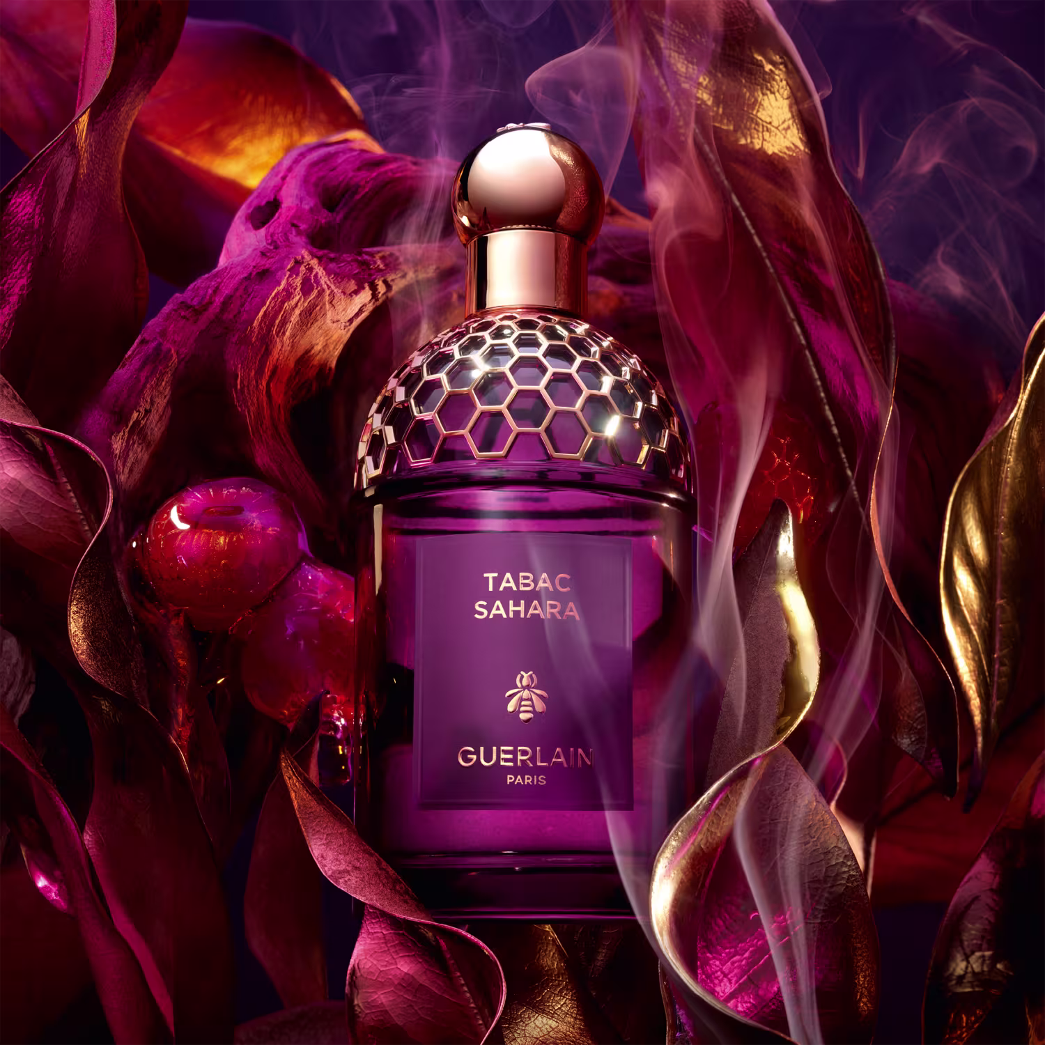 Frasco de perfume Guerlain Tabac Sahara, com design elegante e geométrico em tons de roxo e dourado, destacando o nome da fragrância e a marca.