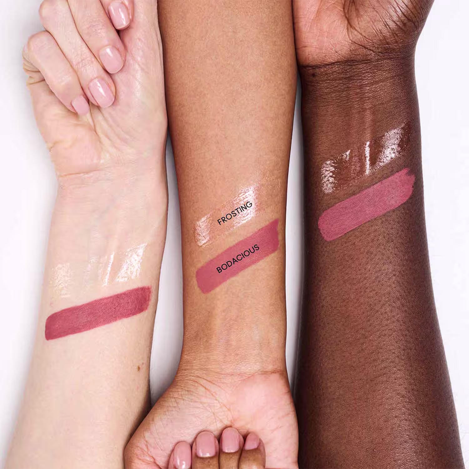 A imagem mostra diferentes tons de pele com marcas de produtos de beleza, como "Frosting" e "Bodacious", em um ambiente de teste ou demonstração de cosméticos.