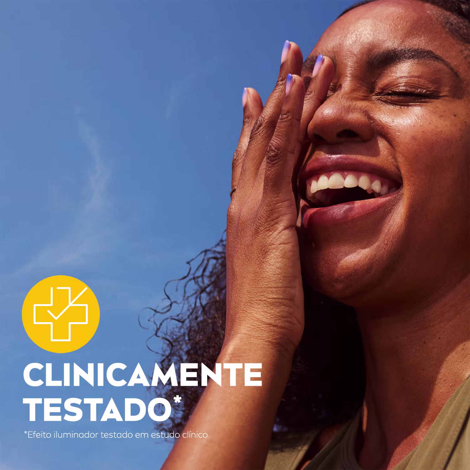 Mulher sorrindo com as mãos no rosto, com texto "Clinicamente testado" e logotipo em fundo azul céu.