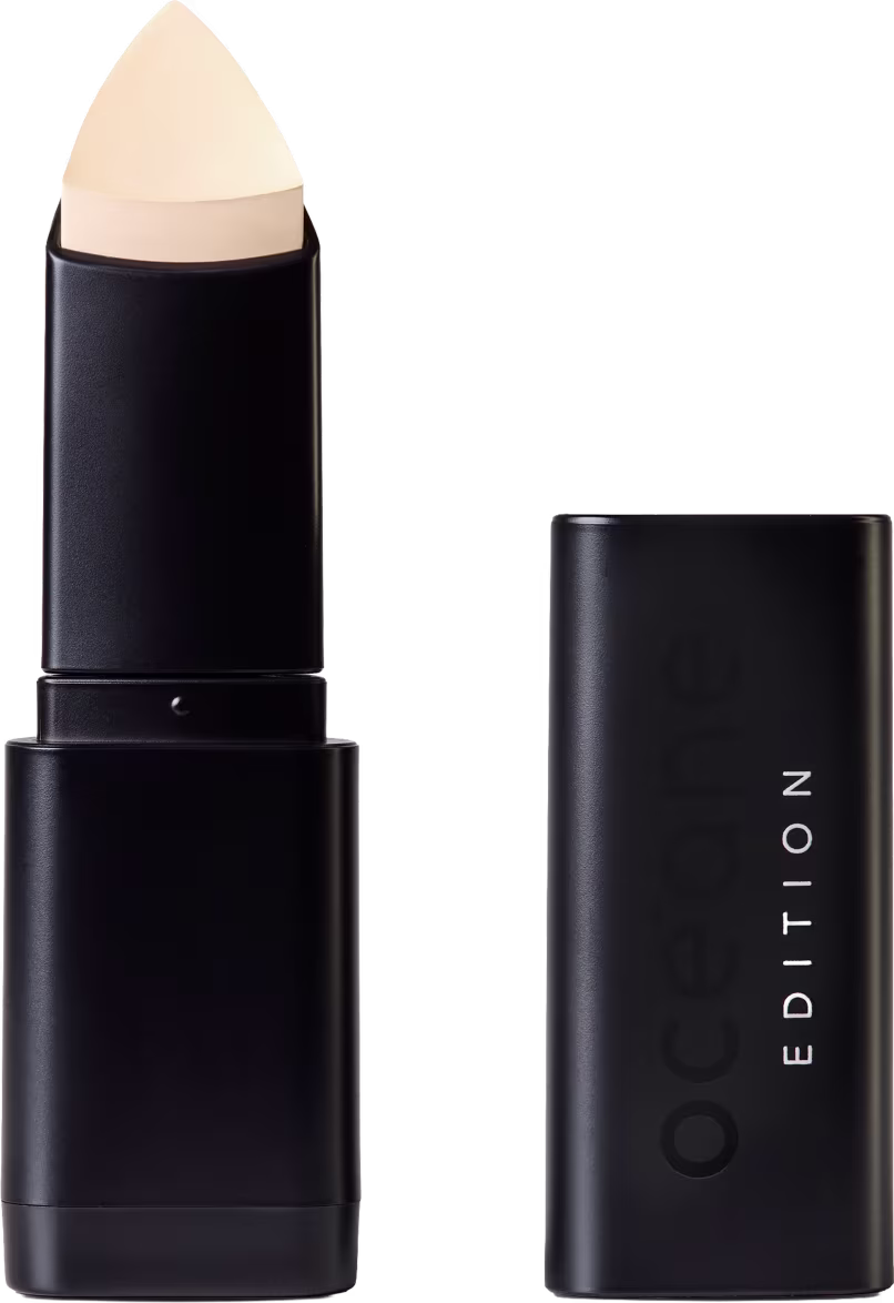 Corretivo em Bastão Océane Concealer Stick. Possui tampa preta e corpo cilíndrico preto liso. Na embalagem, há o texto "EDITION" em letras brancas.