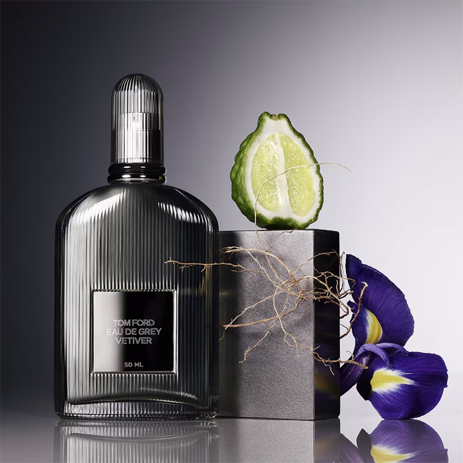 Ambiente elegante e sofisticado com frasco de perfume da marca Tom Ford, acompanhado de elementos decorativos como flor roxa e fatia de limão, em fundo escuro e minimalista.