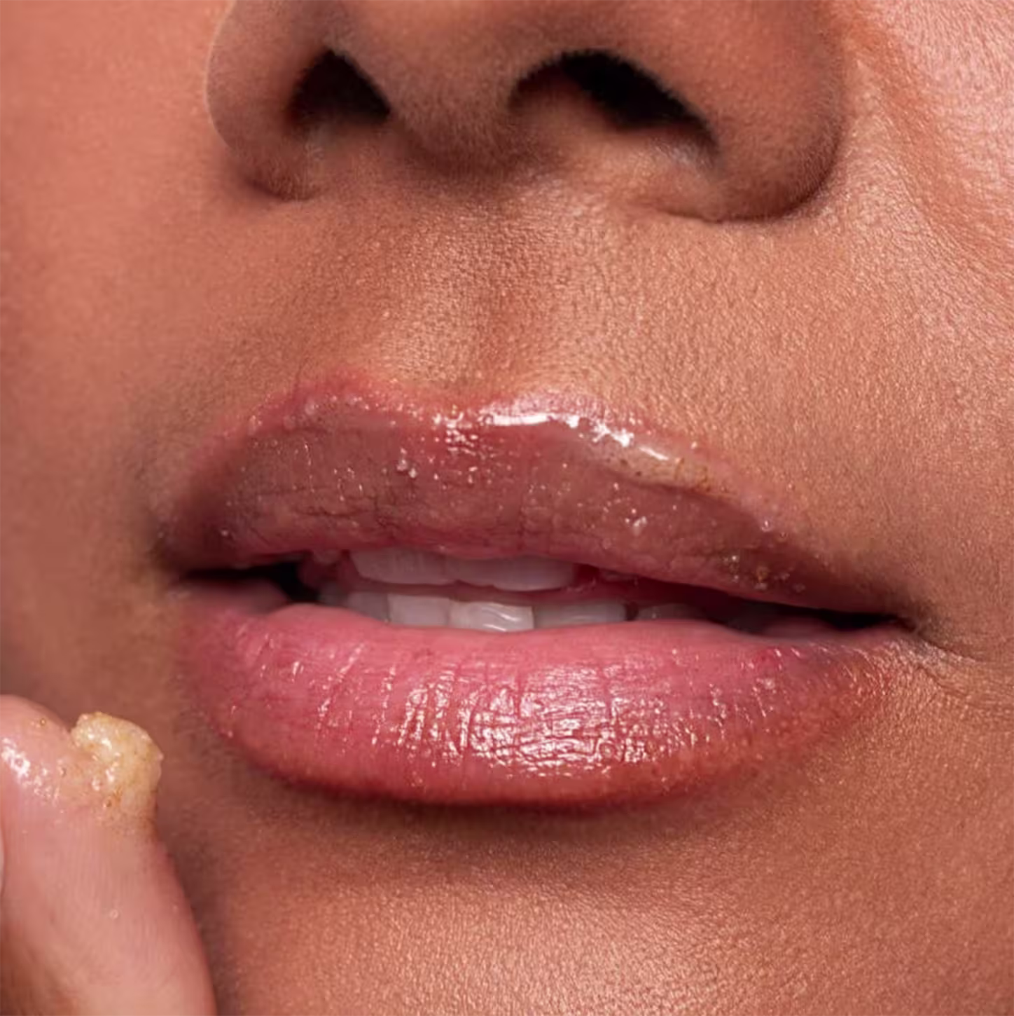 Imagem da boca de uma mulher negra logo após ter aplicado o esfoliante labial CARE Natural Beauty Silky Lips Rose Scrub.