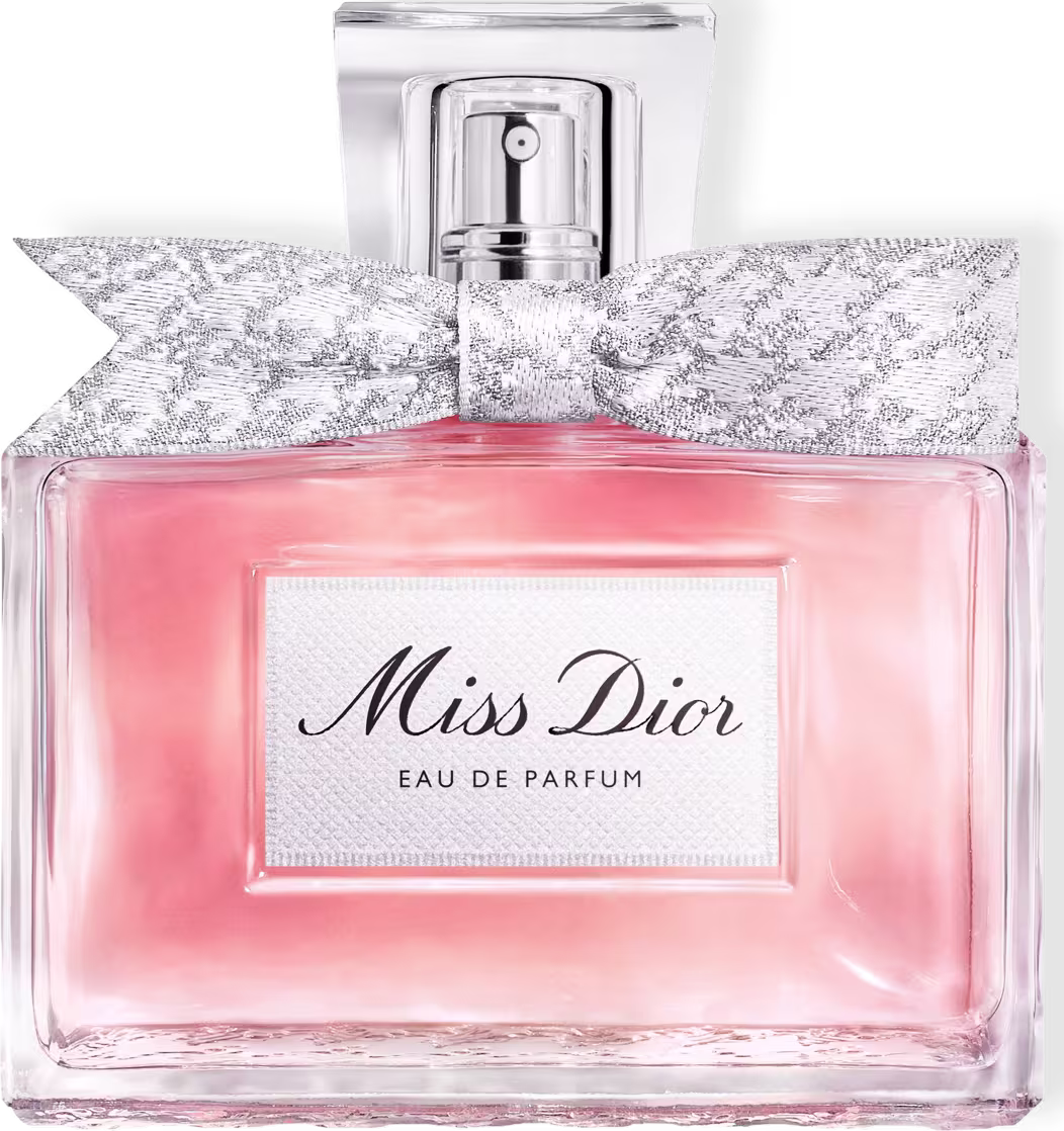 Frasco de perfume Miss Dior em formato retangular com tampa prateada. Embalagem com detalhes em renda branca e rosa claro, com texto "Miss Dior Eau de Parfum" em destaque.