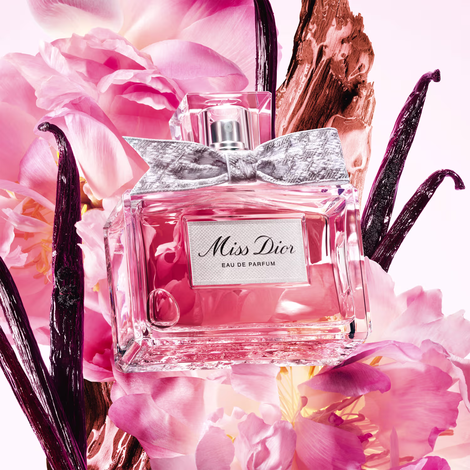 A imagem mostra o perfume Miss Dior ao redor de rosas, baunilha e outros elementos que destacam as notas olfativas.