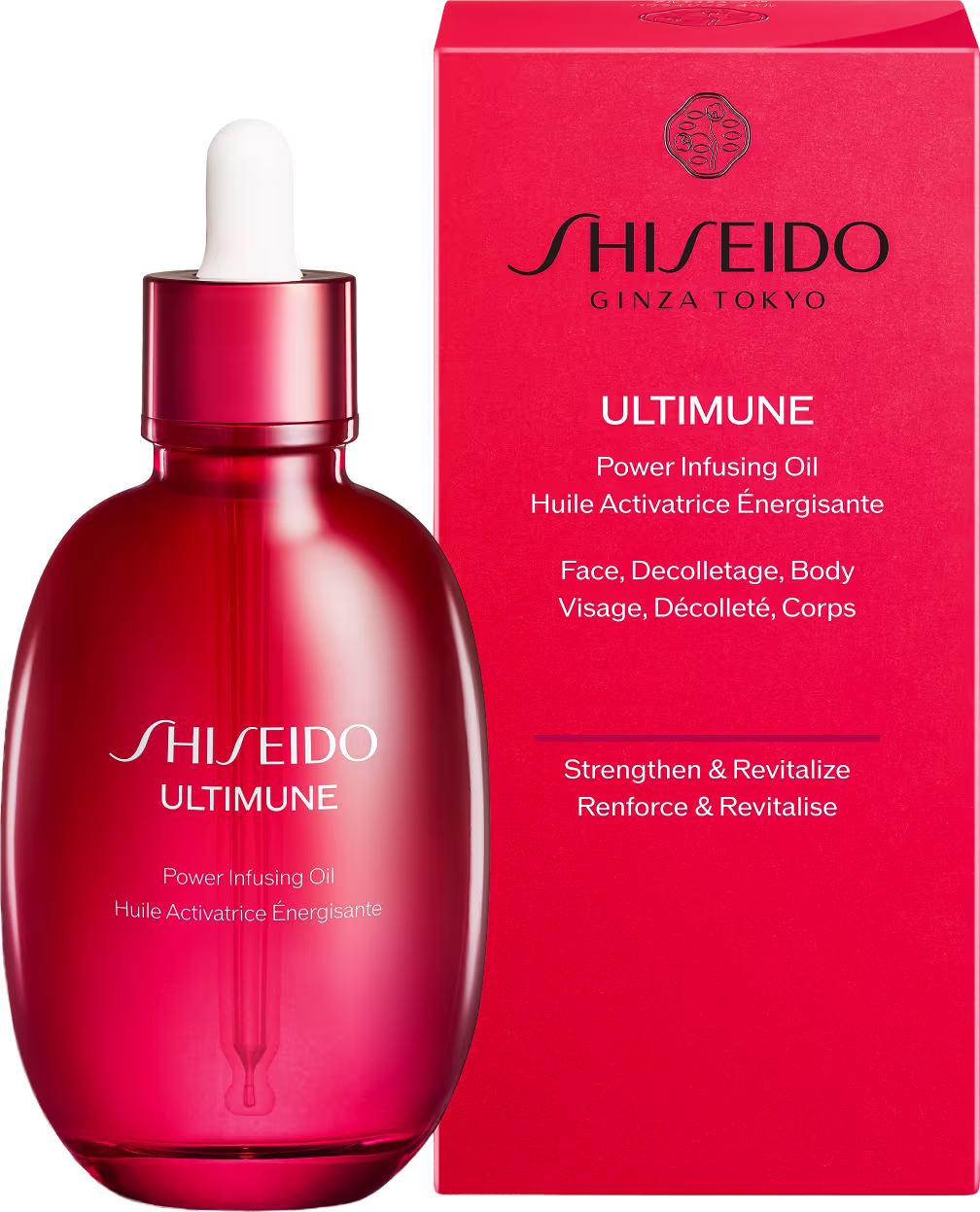 Frasco de vidro vermelho contendo óleo ativador de energia da marca Shiseido, com caixa vermelha e texto em inglês e francês descrevendo o produto para rosto, decote e corpo.