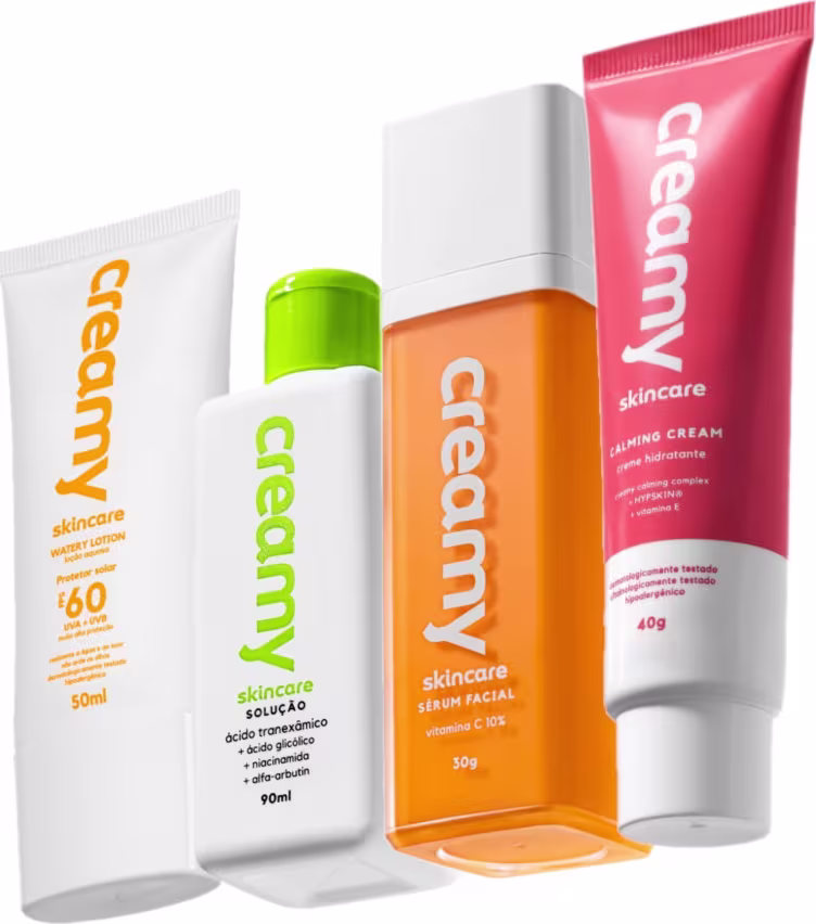 Conjunto de produtos de cuidados com a pele da marca Creamy, incluindo um creme hidratante, uma solução de limpeza, um protetor solar e um sérum facial, em embalagens brancas, verdes e laranjas com rótulos destacados.