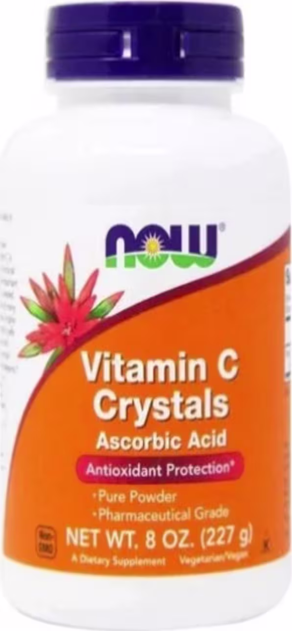 Este é um suplemento alimentar de vitamina C da marca Now Foods. O produto vem em um frasco plástico branco com tampa roxa. A embalagem tem uma etiqueta laranja com o texto "Vitamin C Crystals - Ascorbic Acid".