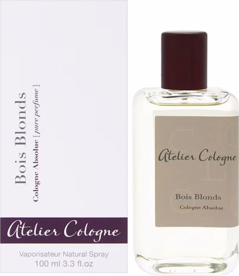 Perfume em frasco de vidro transparente retangular com tampa de plástico marrom escuro. Rótulo bege com o texto "Atelier Cologne" e "Bois Blonds Cologne Absolue" impresso em letras escuras.