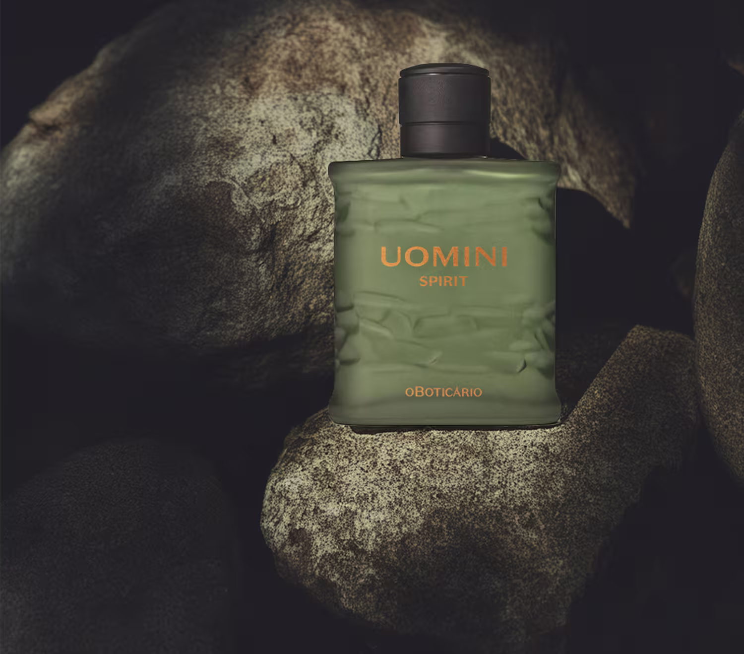 O frasco repousa sobre uma superfície rochosa de aparência áspera e irregular em tons de cinza e marrom que remete a uma caverna.