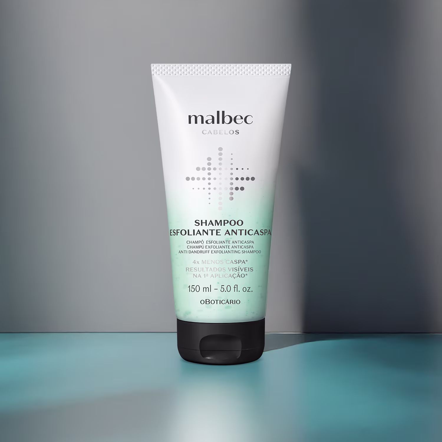 Shampoo esfoliante anticaspa da marca Malbec. Embalagem plástica branca opaca com detalhes em verde claro. Rótulo com o logotipo Malbec e texto descritivo em português e inglês. Frasco cilíndrico de 150ml. Cor preta na parte inferior da embalagem.