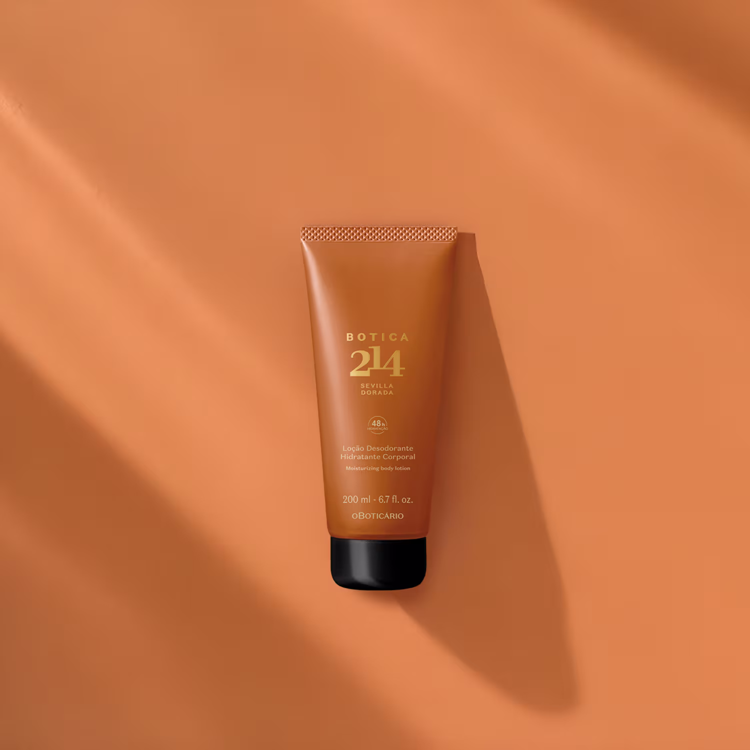 Frasco de loção corporal hidratante da linha Botica 214, com embalagem em tom laranja e detalhes dourados, contendo 200 ml do produto.