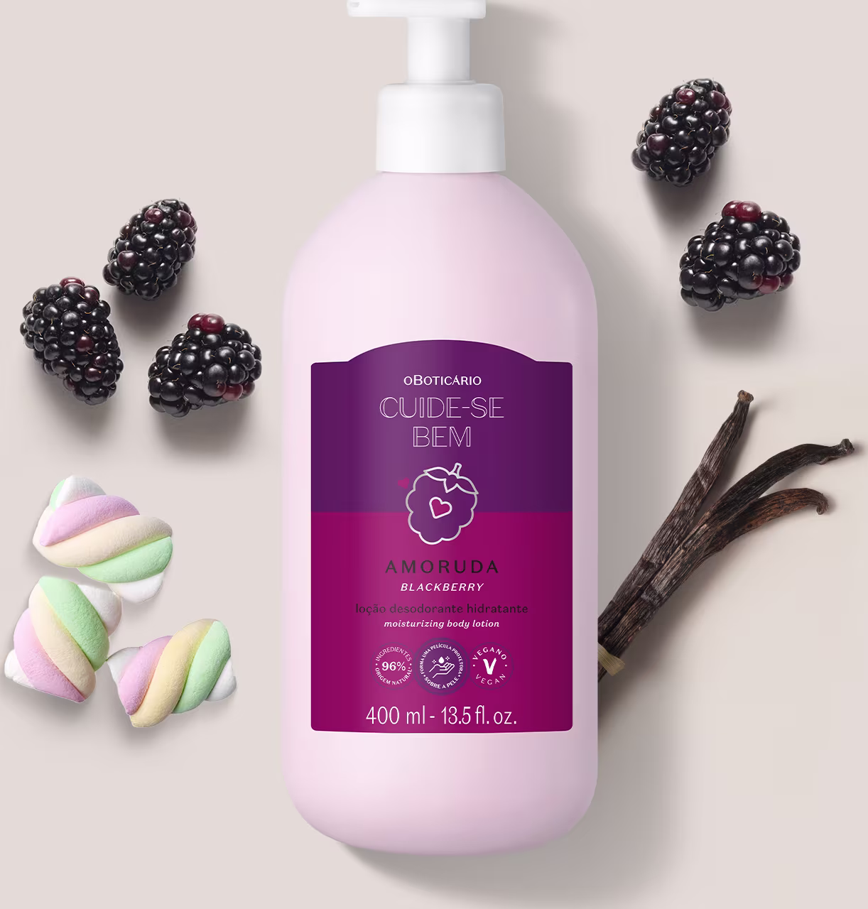 Ambiente de beleza com produto da marca Cuide-se Bem, embalagem rosa e roxa com aroma de amora, rodeado por marshmallows coloridos e frutas frescas, sugerindo um cenário de cuidados corporais e bem-estar.