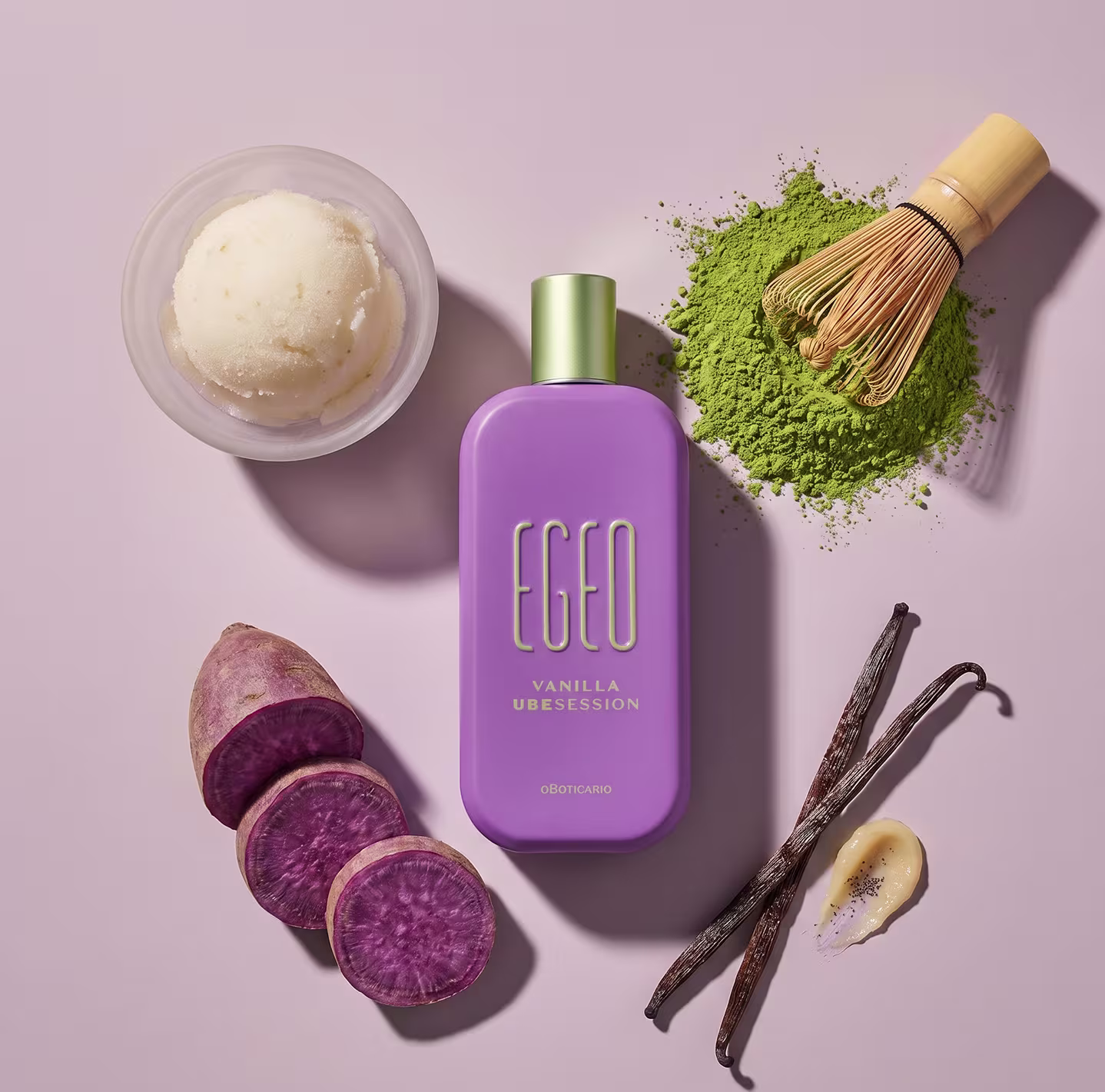 Recipiente de item de perfumaria da marca Egeo em tom lilás, com ingredientes naturais como baunilha, batata-doce roxa e matcha sobre superfície rosa.