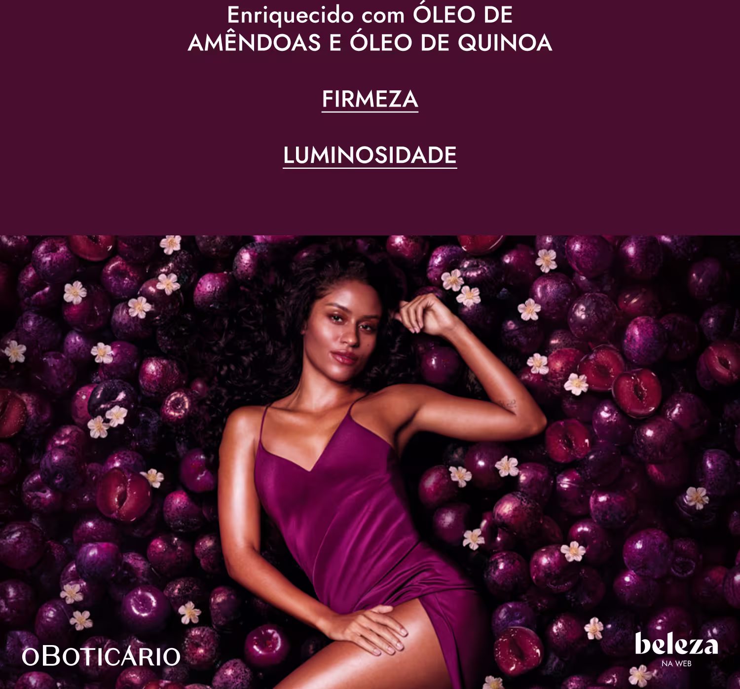Uma mulher de cabelos escuros e cacheados em um vestido roxo está rodeada por ameixas roxas e flores brancas em um fundo escuro. O texto visível diz "Enriquecido com óleo de amêndoas e óleo de quinoa. Firmeza. Luminosidade."