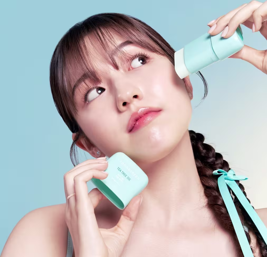 Produto da marca Bringgreen, em tons de azul e verde, com modelo aplicando o produto no rosto, sugerindo um contexto de cuidados de pele.