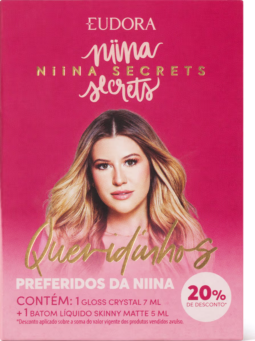 A imagem mostra a frente da caixa do produto, toda rosa, com a foto da dona da linha, e informações sobre os produtos escrito em rosa, dourado e branco.