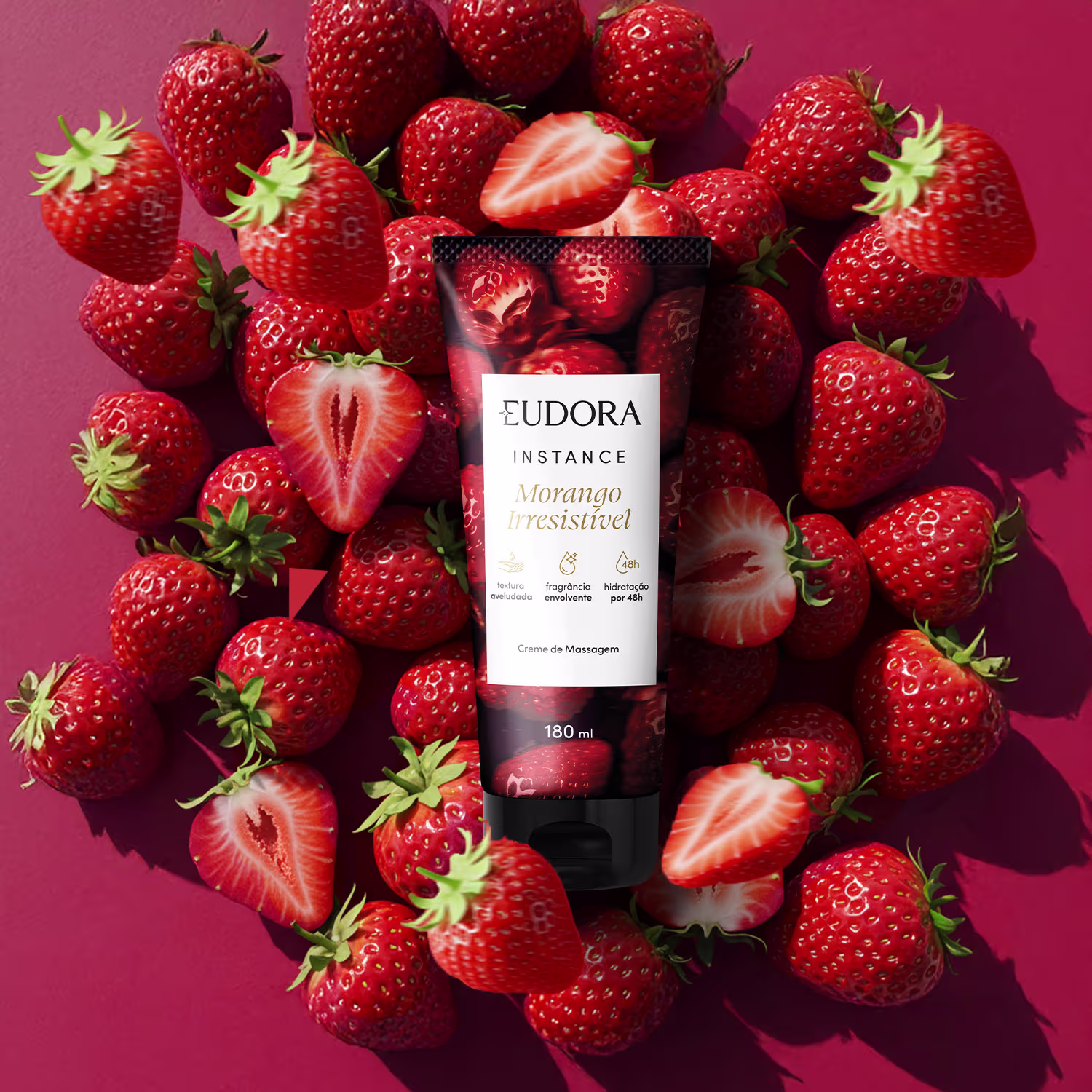 O produto de beleza apresentado na imagem é um creme de massagem de Instance Morango Irresistível. O creme está posicionado em meio a um arranjo de morangos vermelhos e maduros, que preenchem a imagem.