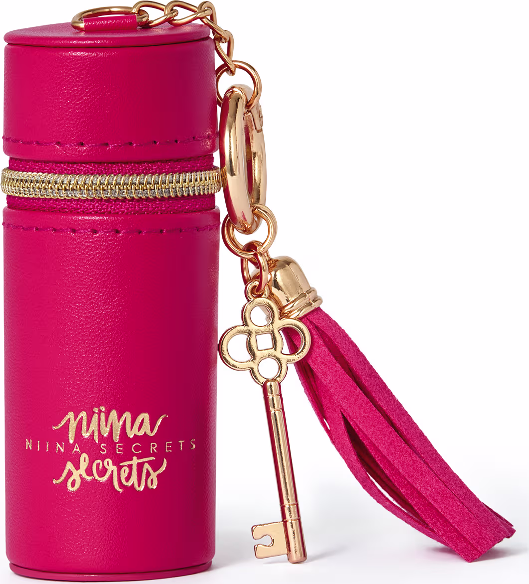 Acessório Porta Batom da marca Niina Secrets, em formato cilíndrico, com tampa rosada e detalhes dourados, com texto impresso "Niina Secrets" em dourado. Com pingente em forma de chave dourado.