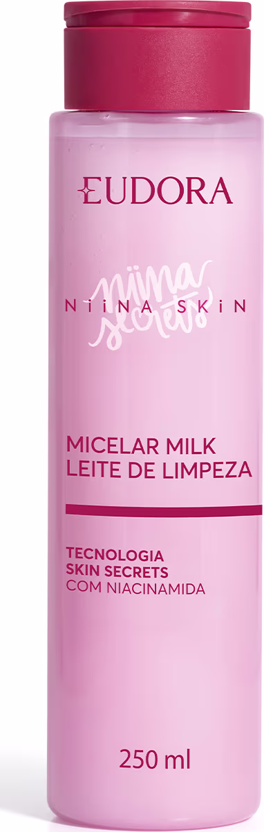 Frasco rosa de 250 ml de leite micelar da linha Niina Secrets da marca Eudora, com tampa vermelha e texto em português descrevendo o produto como "Leite de Limpeza" com tecnologia Skin Secrets com niacinamida.