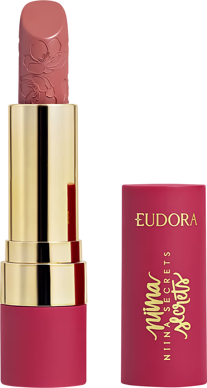 Batom rosa-coral com textura aveludada em embalagem dourada com detalhes florais, marca Eudora impressa em vermelho.
