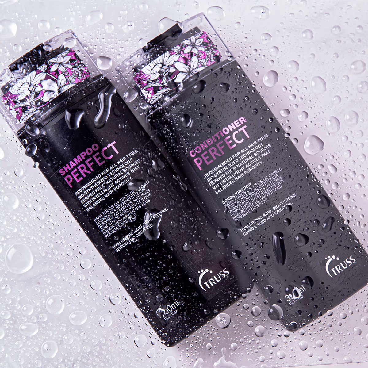 A imagem mostra dois produtos da linha Perfect, da marca Truss: um é o shampoo e, o outro, é o condicionador. Ambos estão em uma superfície molhada.