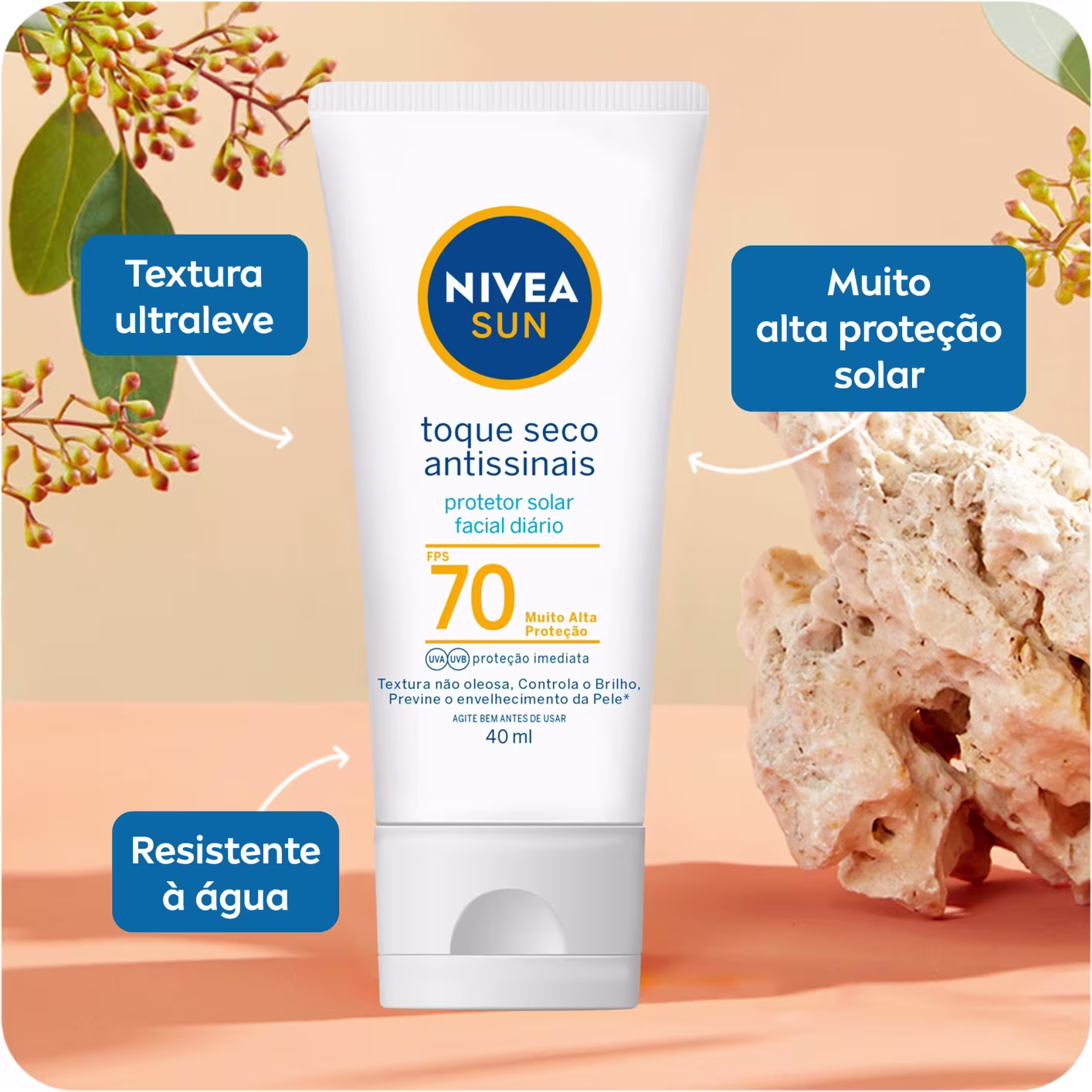 A imagem mostra a embalagem tubular branca do protetor solar facial. O fundo traz alguns galhos e algumas caixas com informações sobre esse produto.