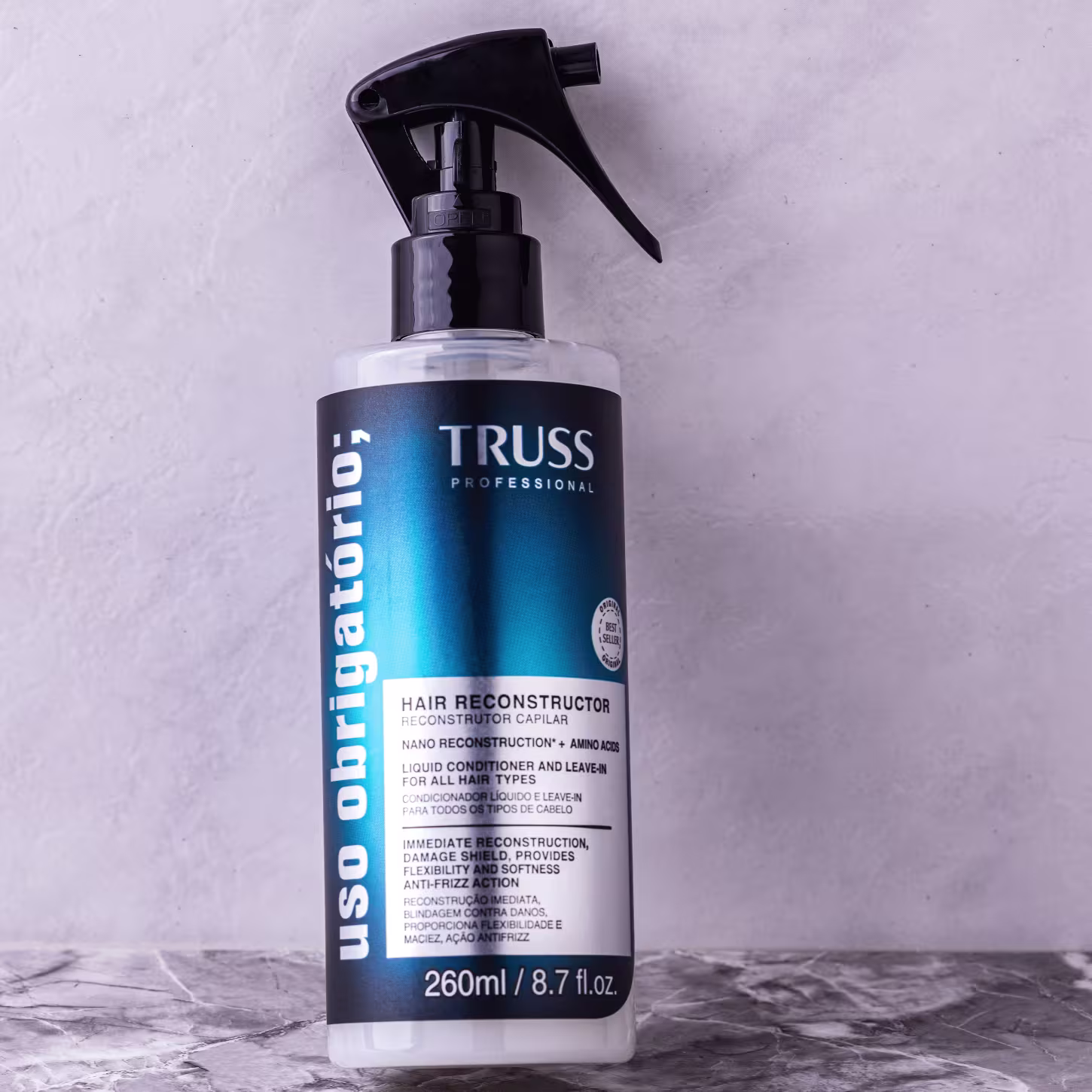 Produto de reconstrução capilar TRUSS Professional. Embalagem plástica transparente com spray acionado por bomba. Cor predominante azul escura na embalagem com detalhes em branco. Rótulo com o nome do produto "Hair Reconstructor".