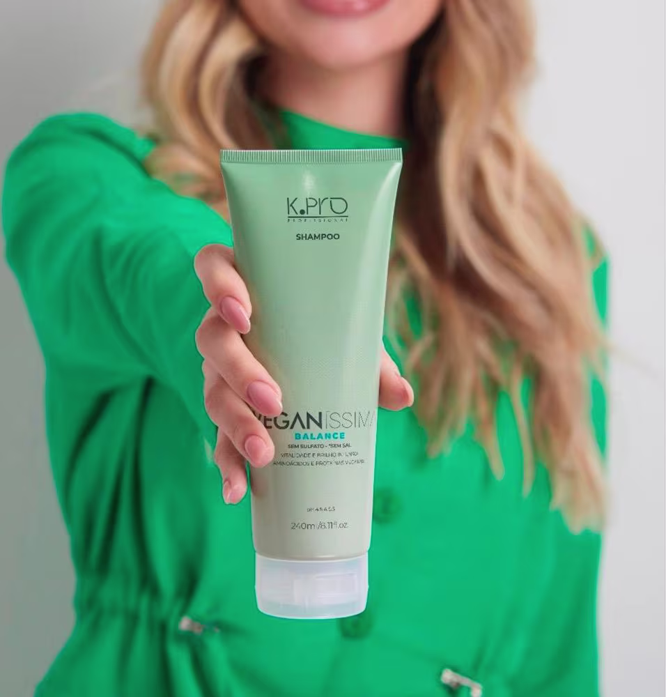 A imagem mostra uma mulher segurando o shampoo.