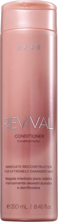 Condicionador Revival da marca Braé. Embalagem cilíndrica de plástico rígido na cor rosa metálico. Rótulo com o nome do produto "Revival Conditioner" e descrição "Immediate Reconstruction for Extremely Damaged Hair" em letras vermelhas.