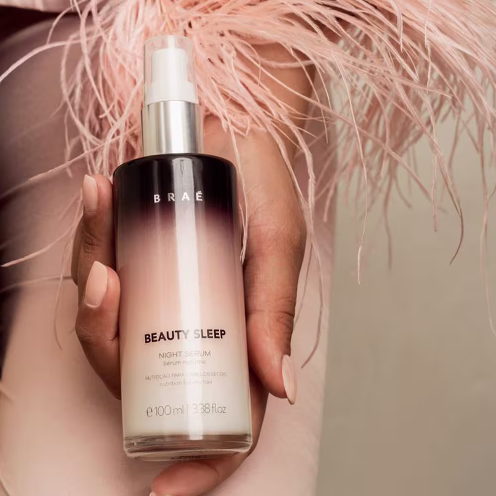 Produto de cuidados noturnos da marca Braé. Frasco plástico transparente com tampa branca, contendo um sérum líquido incolor. Rótulo preto e branco com o nome do produto "Beauty Sleep Night Serum" e informações como volume de 100ml.