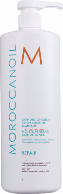 A imagem mostra o Condicionador Moroccanoil Moisture Repair 1L, um frasco branco com letras em azul, laranja e preto. A embalagem tem um dosador no topo.
