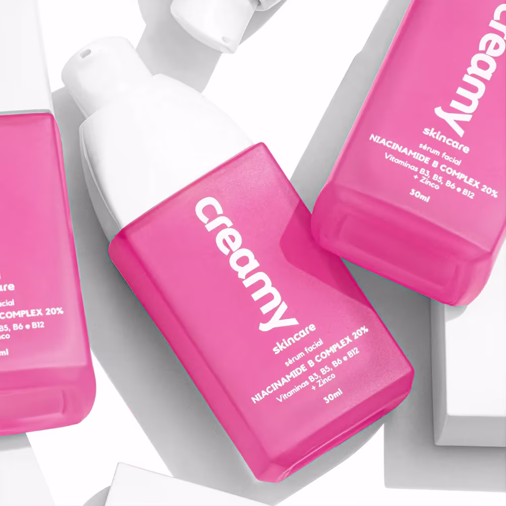 A imagem mostra dois frascos retangulares transparentes do produto cor rosa e tampa branca.