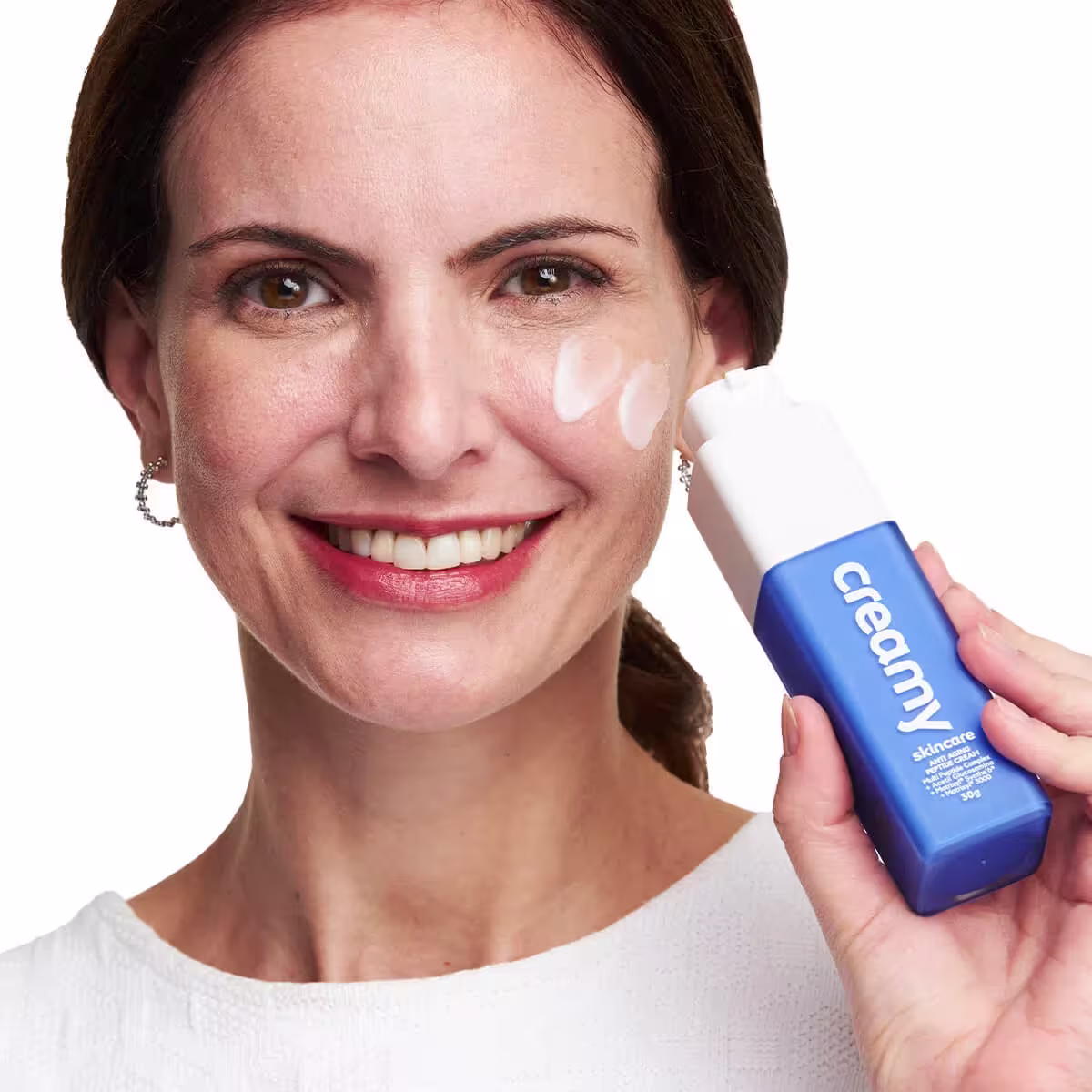 A imagem mostra uma mulher segurando o produto próximo ao rosto.