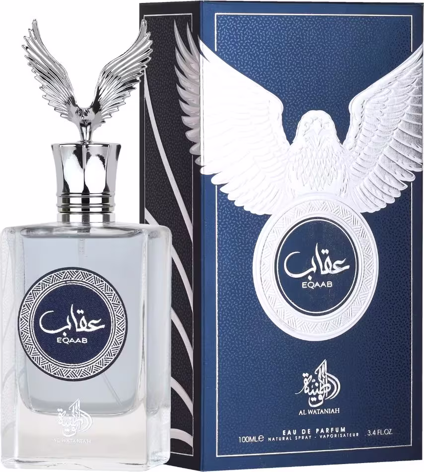 Frasco de perfume Al Wataniah com design elegante e embalagem azul escura com detalhes em prata. O frasco possui um bico em forma de asas de águia. A caixa exibe o nome da marca "Eqaab" em árabe e inglês, com o logotipo da águia.