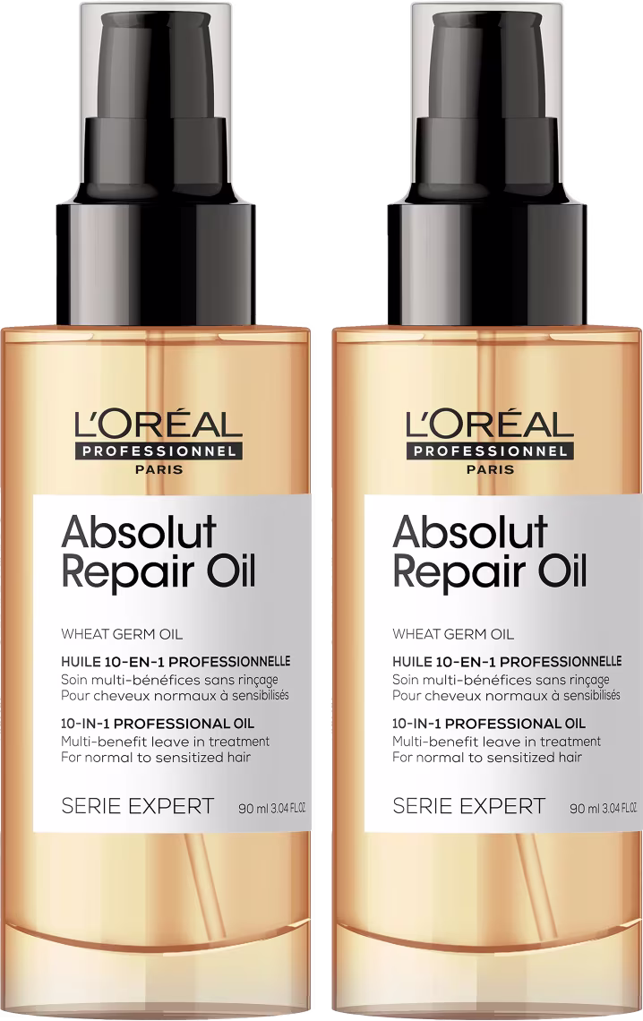 Dois frascos de óleo reparador Absolut Repair Oil da linha Serie Expert da L'Oréal Professionnel. Os frascos são de plástico transparente com tampa preta fosca. O rótulo indica que é um óleo de gérmen de trigo 10 em 1. O volume é de 90 ml